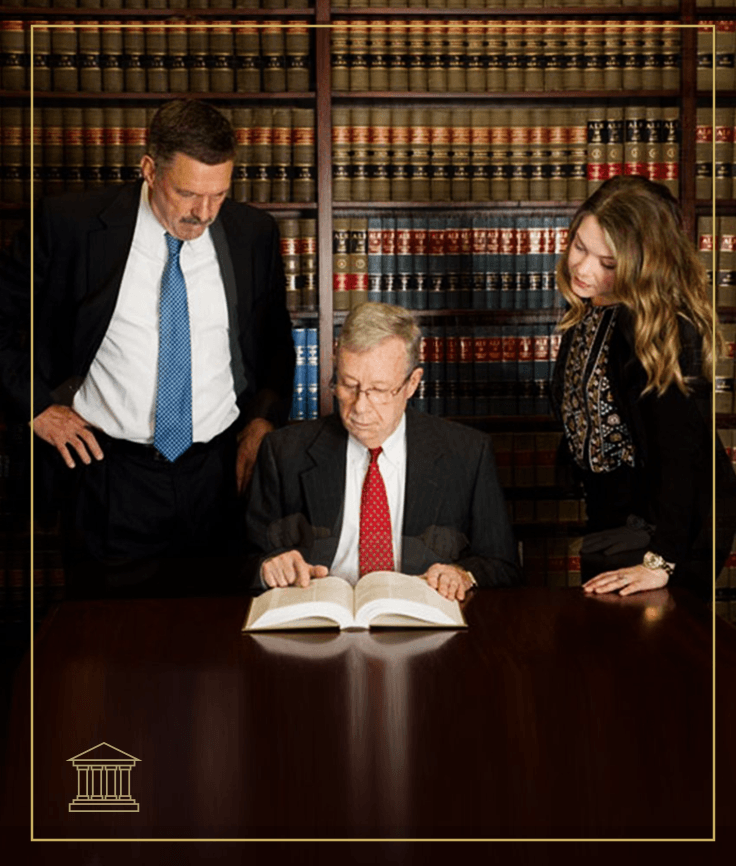 Henry, Williams & Kinder, P.C. attorneys reviewing a law book in the firm's library